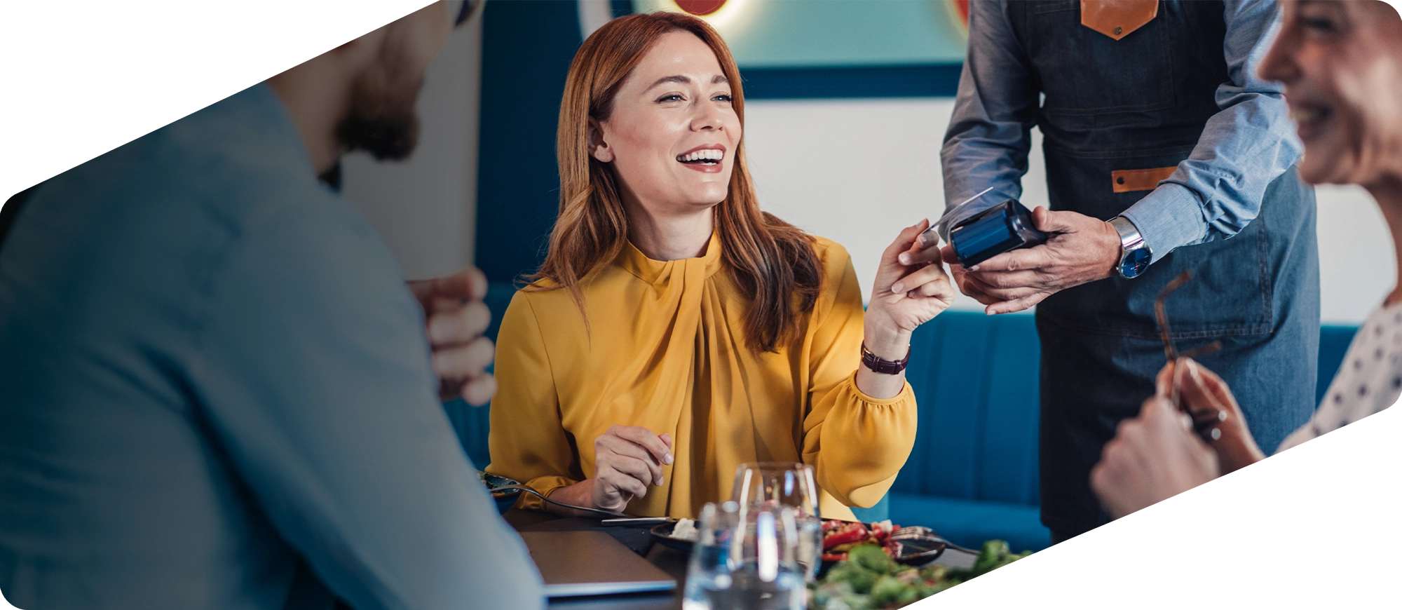 Cliente a pagar com cartão num restaurante, num ambiente descontraído com amigos