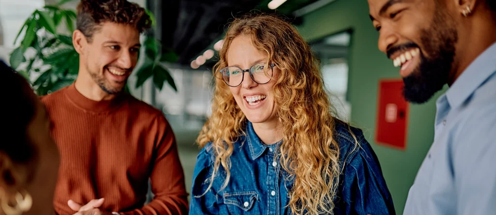 Colaboradores a rir e a conversar num escritório